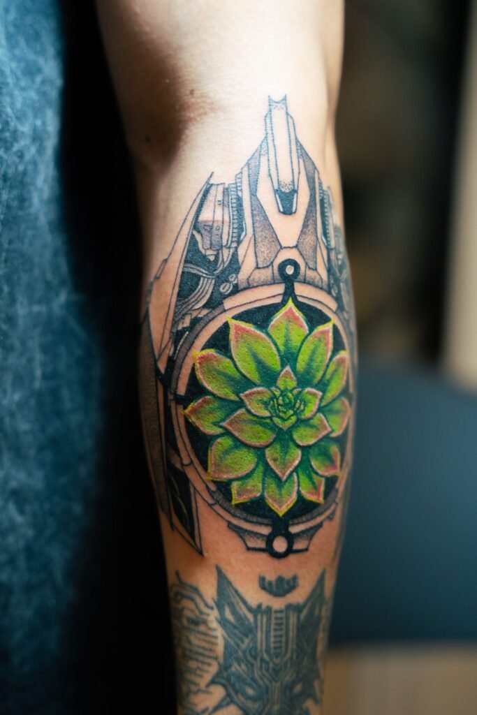 Tatuaje mandala geométrico con una flor verde en el centro, en una pantorrilla